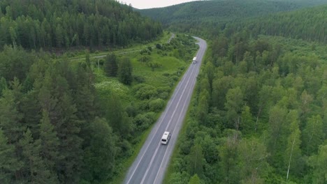 aerial view of a road winding through a forest