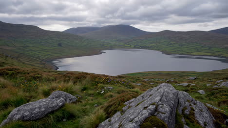 man overlooking a serene mountain lake landscape
