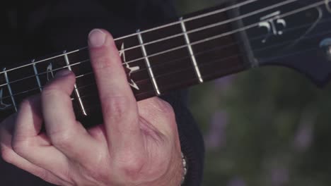 close-up of hands playing an electric guitar