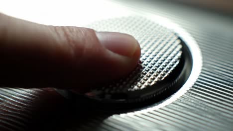 an intricate close-up of a textured button with a finger about to press, showcasing modern design and attention to detail in everyday technology