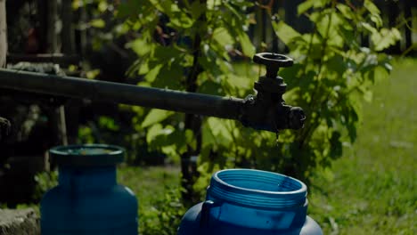 Home-water-pump-dripping-water-in-a-bucket,-close-up