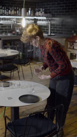 person setting tables in a modern restaurant or bar