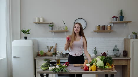 Pretty-young-girl-coming-to-the-table-with-juicy-apple.-Cutting-with-knife-and-eating-fresh-fruit