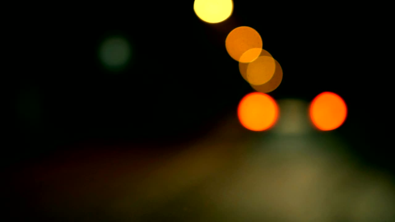 conducir un coche a través de la carretera de la noche, la autopista. luces desenfocadas calle de los ángeles resumen. ciudad fondo borroso. movimientos círculos bokeh de tráfico nocturno.