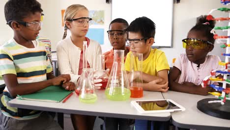 School-kids-doing-chemical-experiment-in-classroom