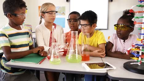 niños de la escuela haciendo experimentos químicos en el aula