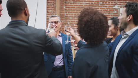 Mature-Businessman-Makes-Speech-To-Business-Team-And-Celebrating-Success-With-Toast-In-Modern-Office