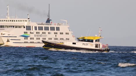 a pilot boat guides a ferry through calm seas near bellarine, victoria. clear skies and steady camera capture the maritime scene