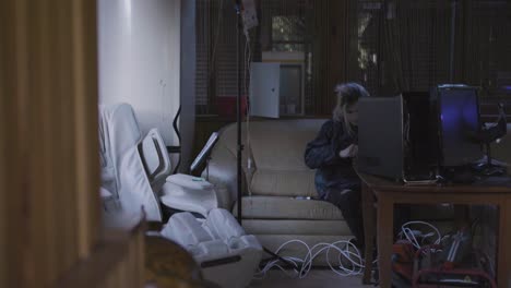 persona en casa con computadoras y silla de masaje