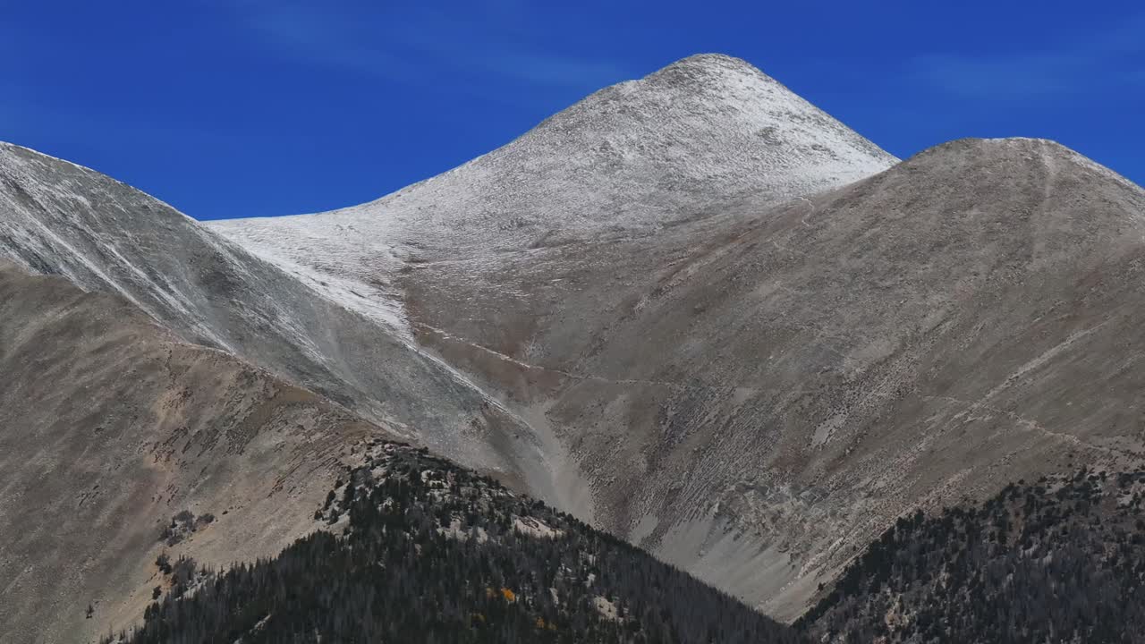 Cool autumn fall morning clear blue skies trail up 14er Mt Mount Shavano aerial drone Colorado Trail Tabeguache Peak Aspen Trees yellow orange colors snow dusting Rocky Mountains parallax right motion