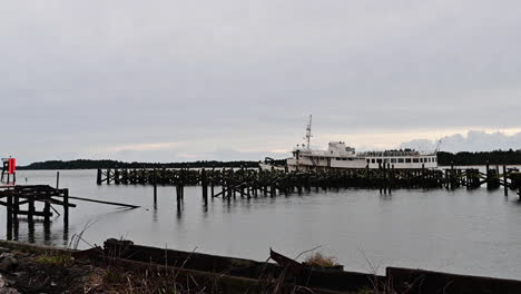 old boat moored by wood pilings at empire dock in coos bay, oregon