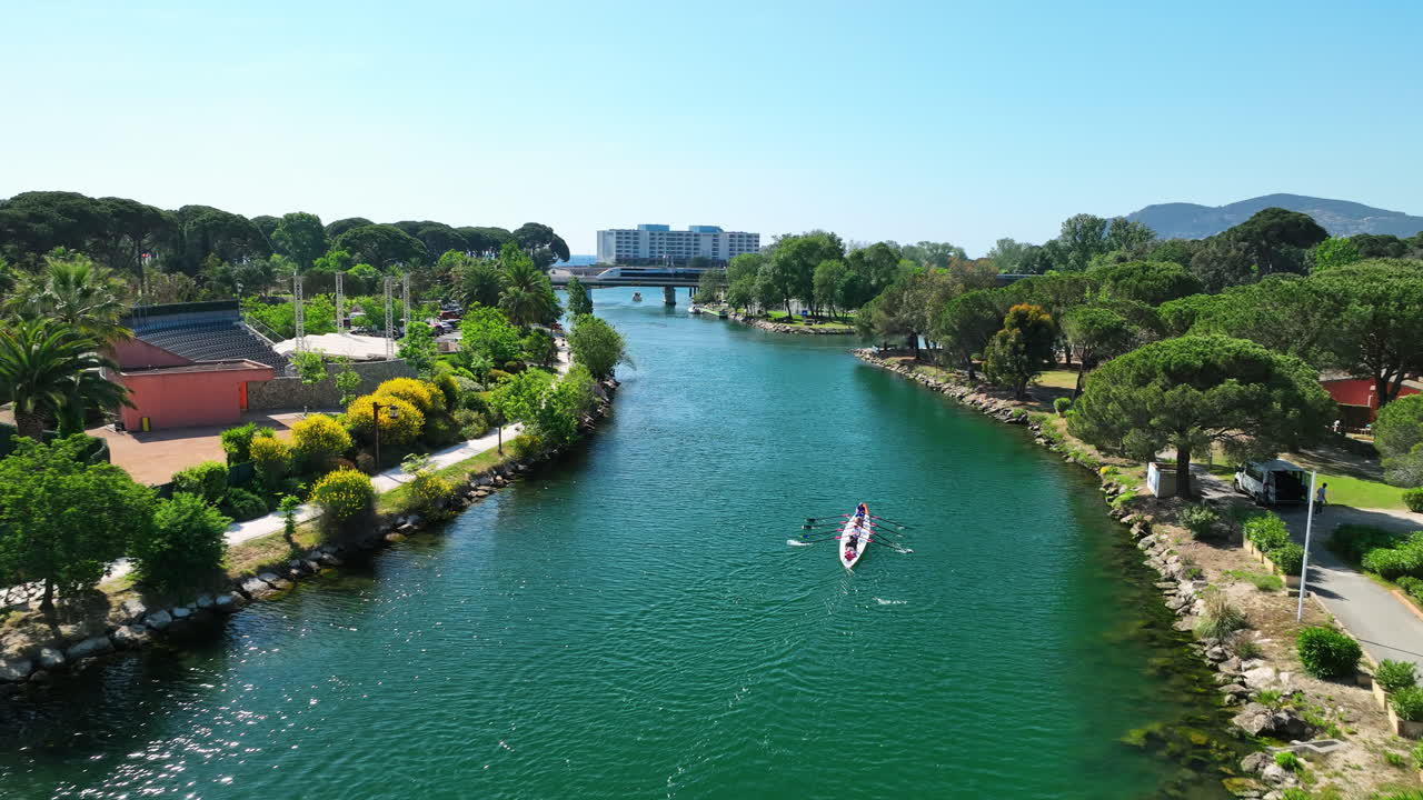 Rowing on the La Siagne River, aerial view, with a train and sea in the backdrop