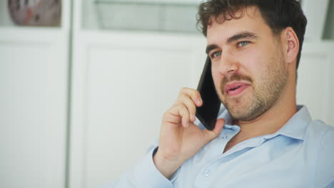 Hombre-Feliz-Hablando-Por-Teléfono-En-Casa