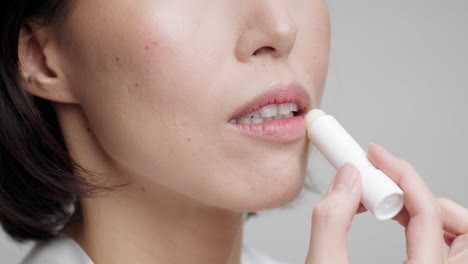 mujer aplicar bálsamo labial