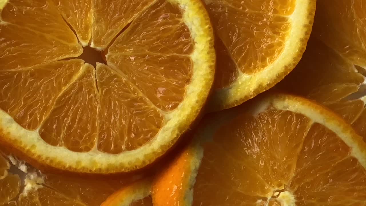 una rebanada de fruta de naranja girando. con ruido y fondo de bokeh enterrado.