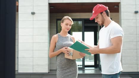 Glückliche-Frau-Trifft-Lieferboten-Mit-Papierschachtel.-Lächelnde-Frau,-Die-Ein-Paket-Entgegennimmt