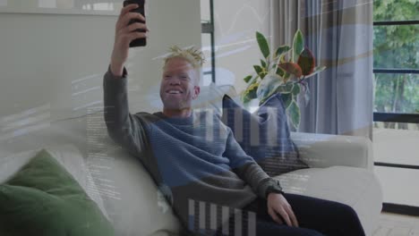 Animation-Von-Grafiken,-Globen-Und-Einer-Karte-über-Einem-Afroamerikanischen-Albino-Mann,-Der-Ein-Selfie-Mit-Dem-Handy-Macht