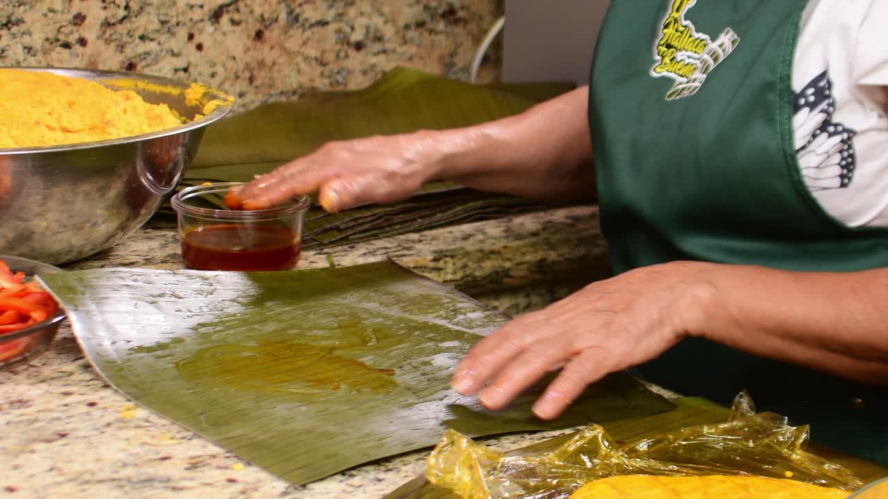 Primo piano della masa gialla spalmata con olio di onoto su una foglia di banana (alimento)
