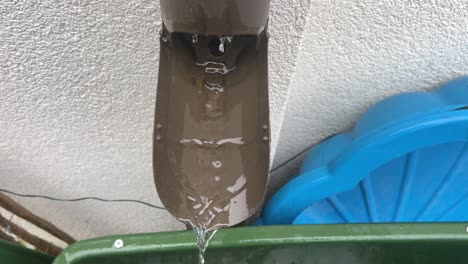 top down close up shot of water flowing out of a typical german drain pipe during rain