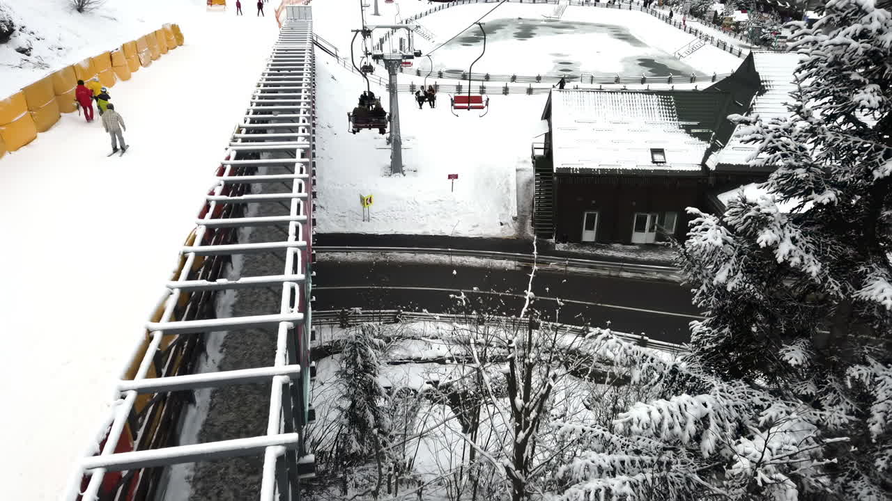 Bukovel, Ukraine -January 30, 2022: In a picturesque mountain resort, families and friends are seen skiing and enjoying the snow-covered slopes on a bright winter day. The atmosphere is lively and cheerful