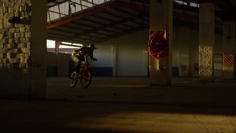 bmx rider in an empty warehouse