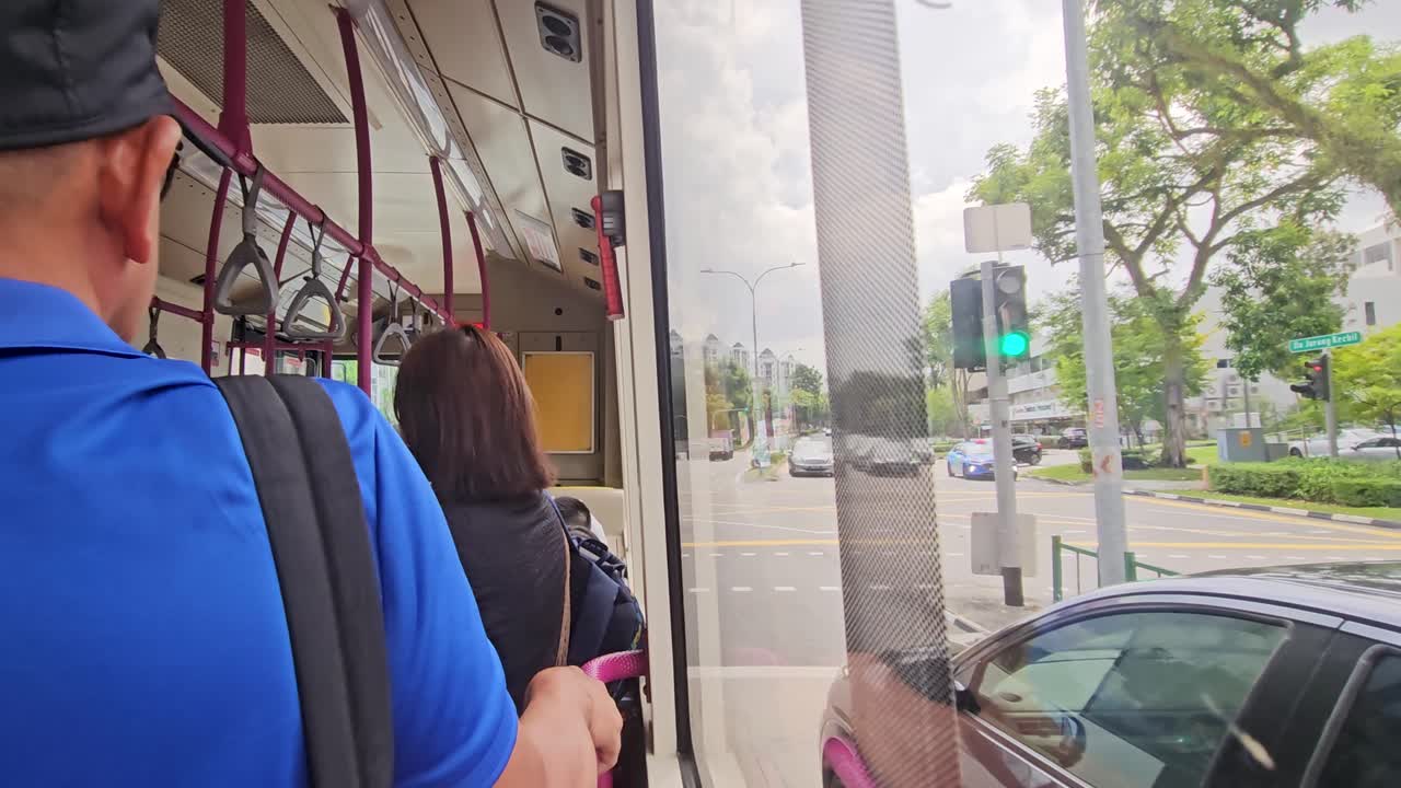 Man and woman riding the bus and waiting for the stop light to turn green