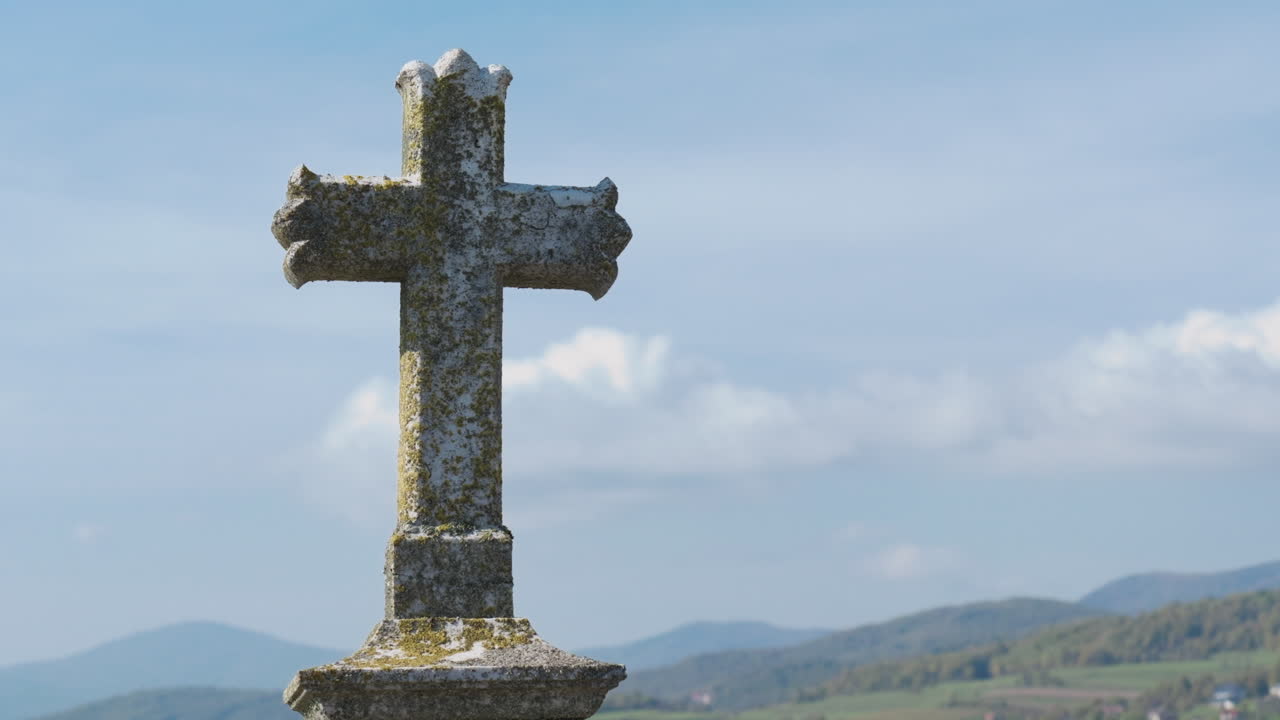 Weathered stone cross overlooking a tranquil valley, evoking themes of faith, remembrance, and the passage of time