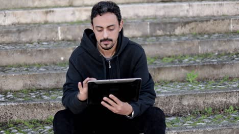 Serious young man with digital tablet