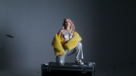 woman in luxury fashion posing with money rain