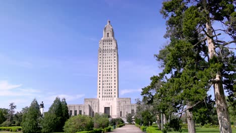 Edificio-Del-Capitolio-Del-Estado-De-Louisiana-En-Baton-Rouge,-Louisiana-Con-Video-Cardán-Caminando-Hacia-Adelante-Con-Un-Gran-árbol