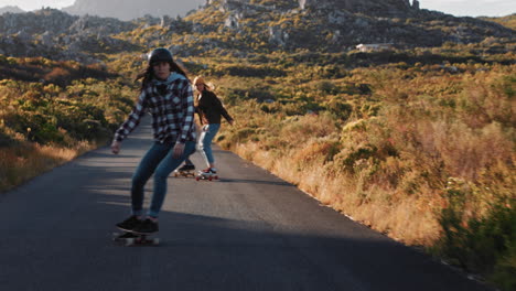 szczęśliwi przyjaciele z wielu narodowości jeżdżą razem na longboardzie, jeżdżą na deskorolce, jeżdżą po wiejskich drogach, bawią się, spędzają czas, cieszą się relaksującymi letnimi wakacjami.