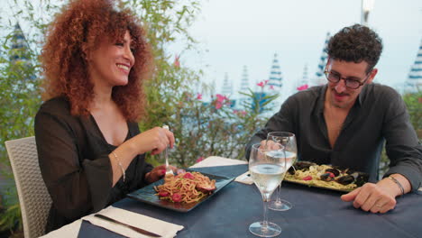 two lovers eating spaghetti at the beach resort for lunch