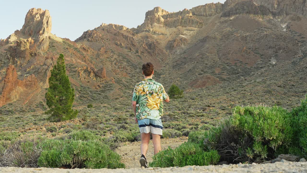 Caucasian tourist in tropical outfit walks through Tenerife's desert