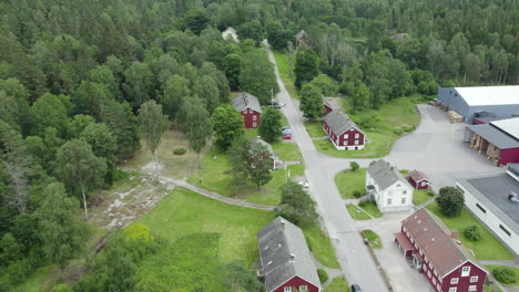 Red buildings and cafe near bäckefors bruk surrounded by nature, aerial view