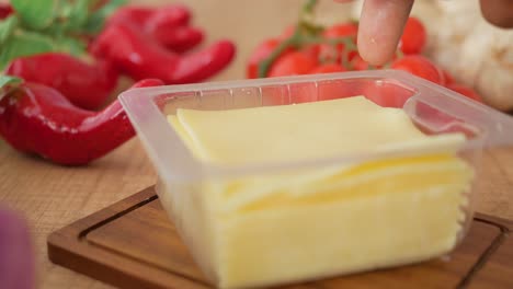 sliced cheese in a plastic container with vegetables