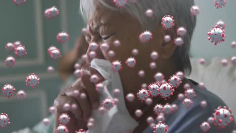 multiple covid-19 cells floating against african american senior woman coughing in the bed at home