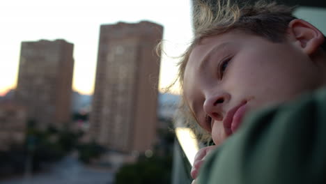 Sad-and-lonely-teenager-boy-looking-at-the-city-from-the-balcony