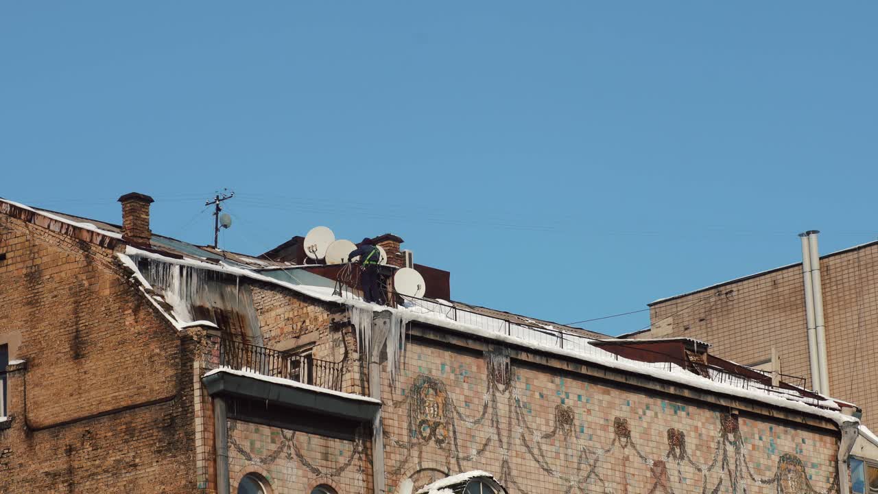 눈 인 지붕 에 있는 노동자