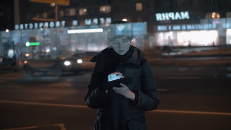 young woman using digital tablet in busy night city