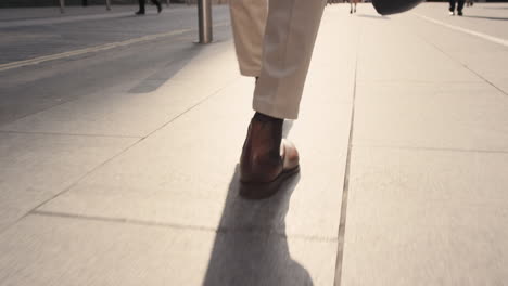 Close-crop-of-businessman-feet-walking-in-city