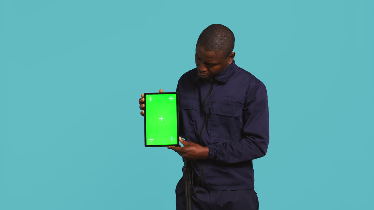 un guardia de seguridad feliz trabajando en un trabajo de protección presentando un modelo de tableta.