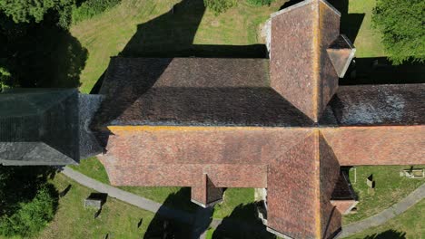 A-top-down-pan-of-St-John-the-Evangelist-church-in-Ickham,-Kent,-clearly-showing-the-cross-shape-of-the-building