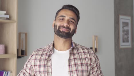 headshot portrait of smiling attracting indian businessman indoors.