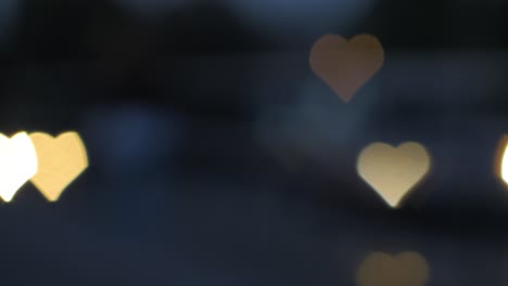 Beautiful-hearts-bokeh-from-moving-car-and-traffic-lights-at-the-evening,-Valentines-Day,-wedding-day-or-social-media-Like-background-concept