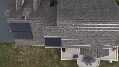 aerial rising shot of solar panels being installed on shingle house roof