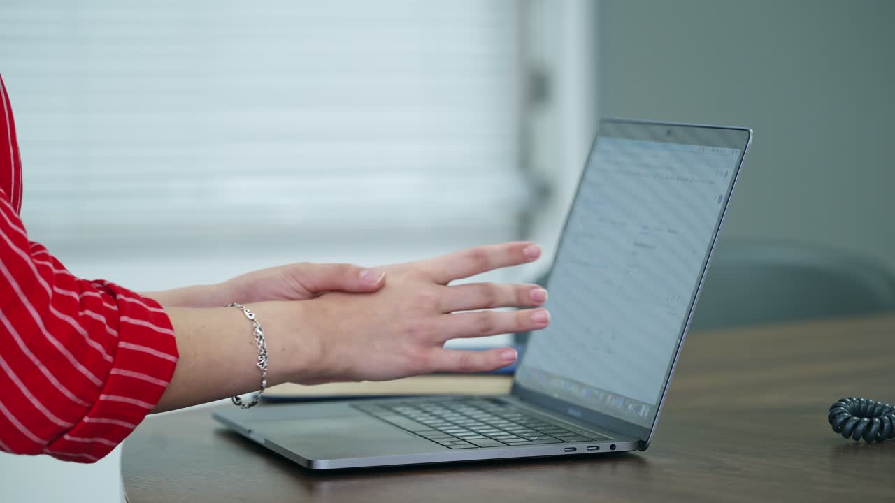 Woman using laptop indoor. Close up of woman working at home office, hand on keyboard