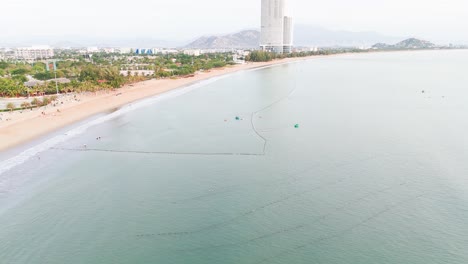 aerial view orbit right of the beach and people in phan rang–tháp chàm.