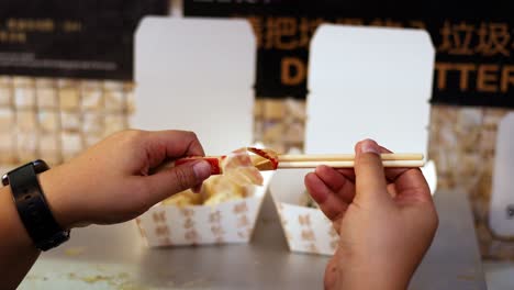 manos preparando palillos para una comida