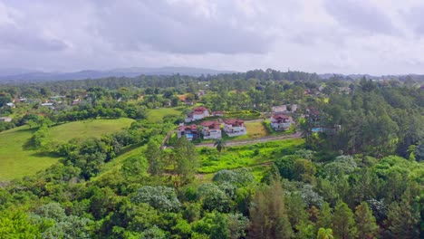 Vuelo-Aéreo-Que-Muestra-Un-Magnífico-Paisaje-Verde-Con-árboles,-Campos-Y-Un-Pequeño-Pueblo-En-Jarabacoa