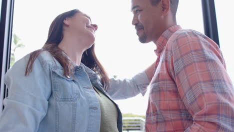 embracing partner, smiling pregnant woman sharing joyful moment together